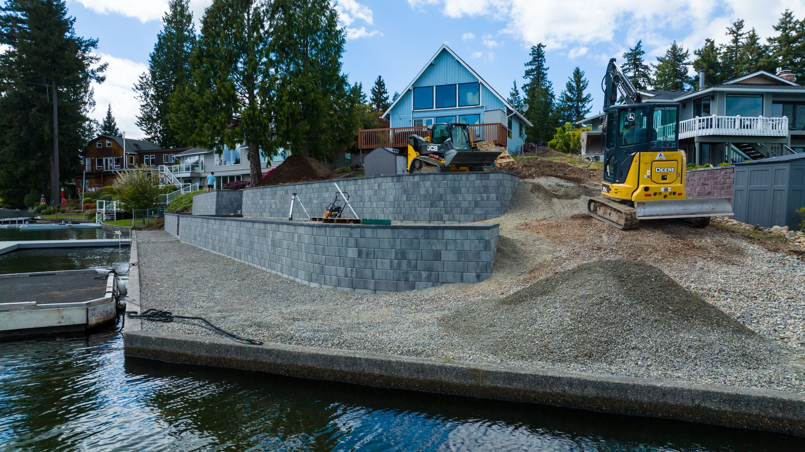 Stone retaining walls built on a lakeside property under construction.